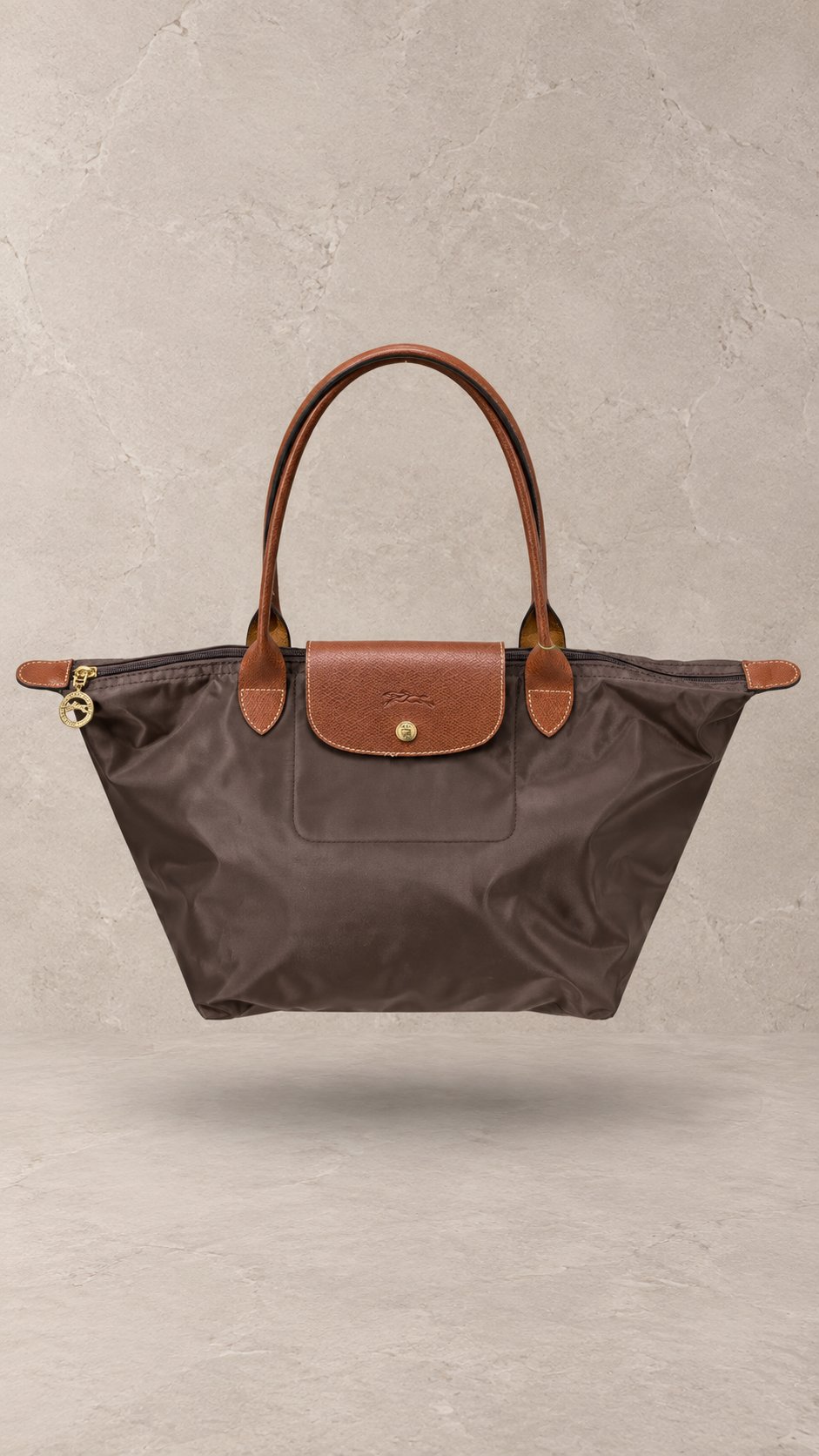 کیف دوشی تاشو زنانه لوشامپ از جنس نایلون با درپوش و بند چرمی با جزئیات یراق طلایی | Floating Longchamp Le Pliage foldable nylon tote bag with brown leather flap, handles, and gold-tone horse medallion zipper pull