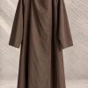 بارانی مینیمال با یقه دراپه مورب و تک‌دکمه چوبی شناور در پس‌زمینه بتنی بافت‌دار | Minimalist asymmetric drape trench coat with raglan sleeves and wooden accent button on textured neutral background