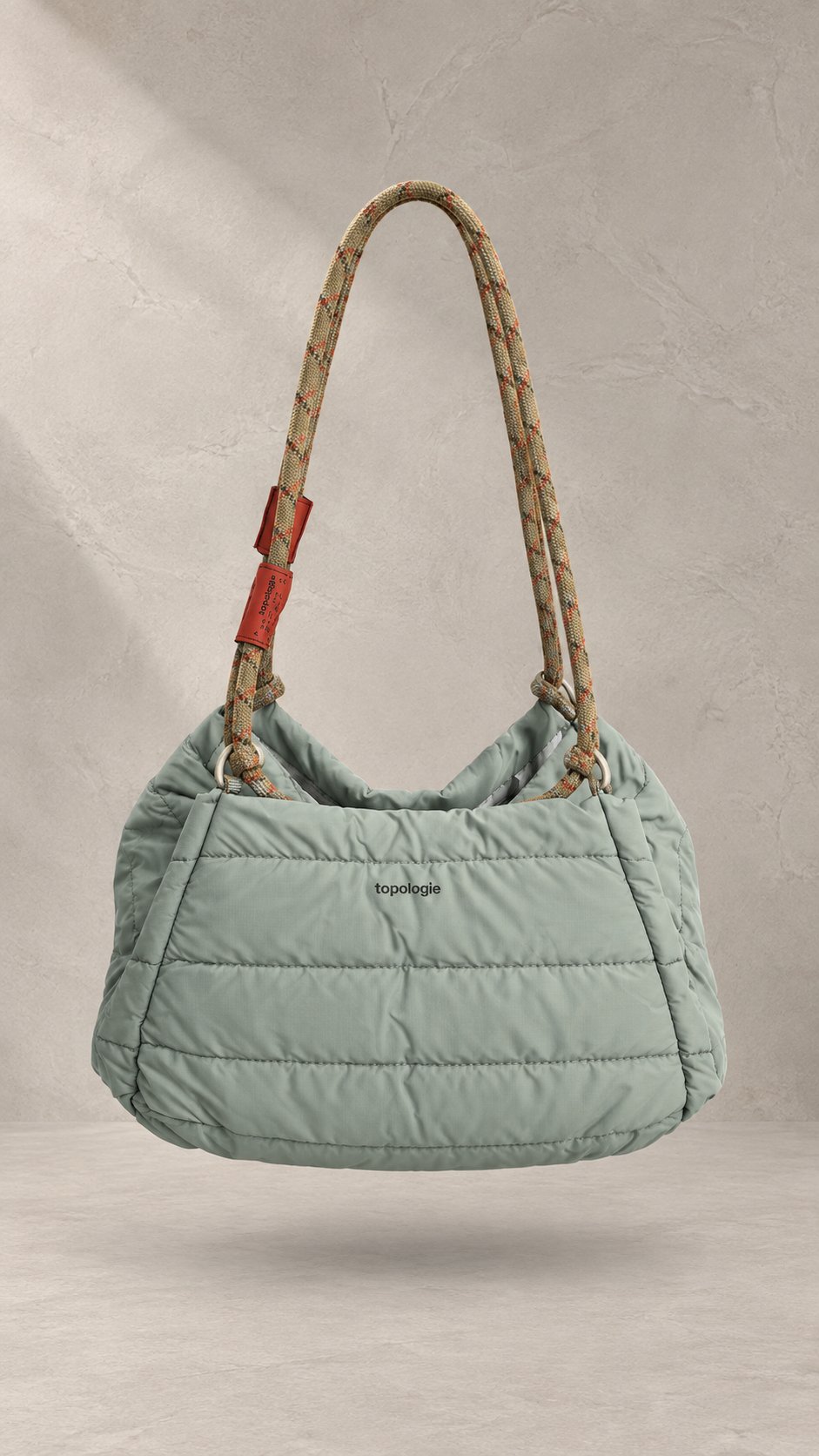 کیف دوشی پف‌دار برند توپولوژی با بند طنابی دو رنگ و لوگوی سفید در استایل | Padded Topologie shoulder bag with contrast rope strap and white logo, in-hand