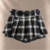 دامن کوتاه زنانه چهارخانه مشکی و سفید طرح پلیسه به همراه کمربند سگک‌دار مشکی | Women’s black and white plaid pleated skirt with an integrated buckle belt