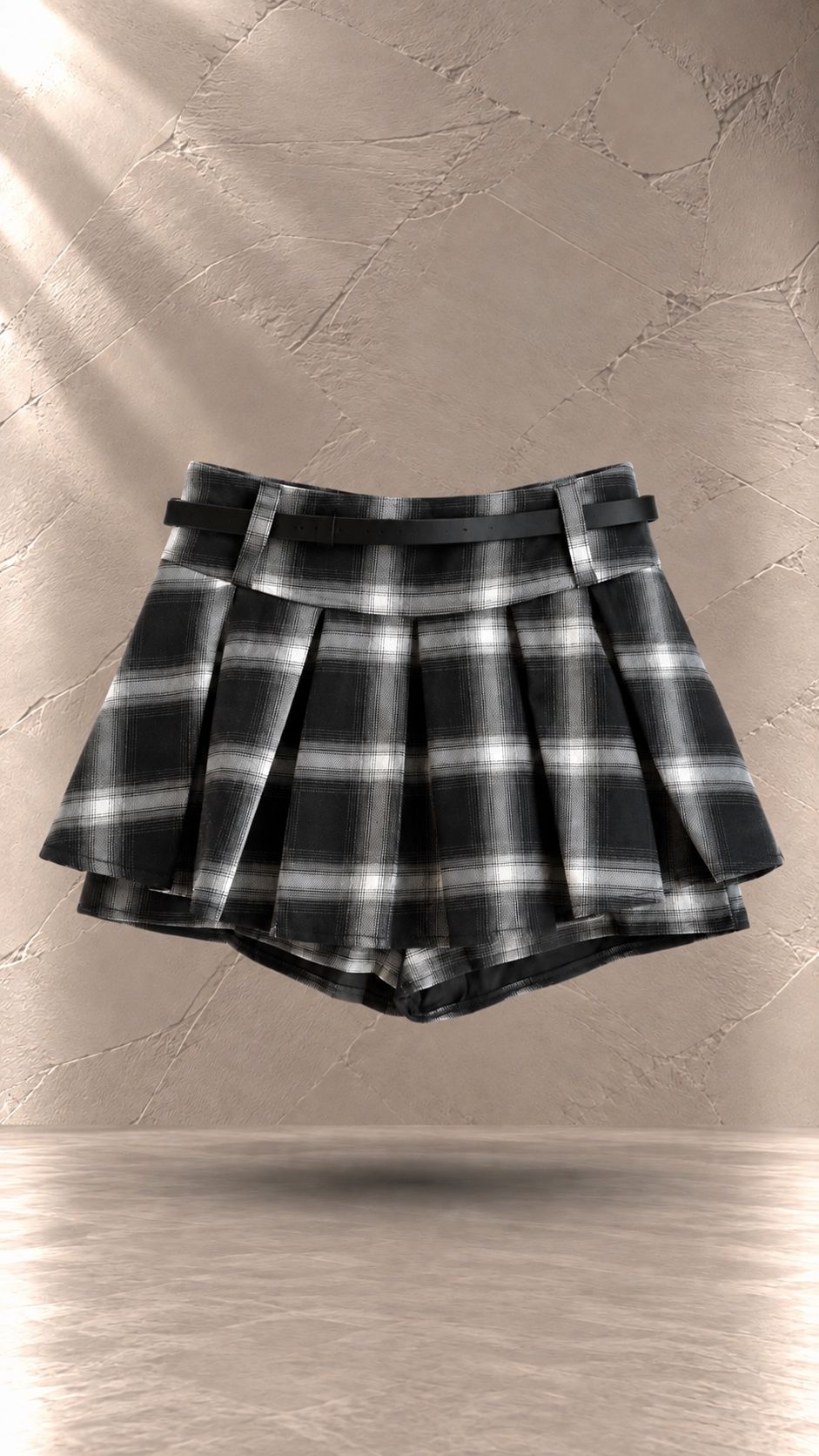 دامن کوتاه زنانه چهارخانه مشکی و سفید طرح پلیسه به همراه کمربند سگک‌دار مشکی | Women’s black and white plaid pleated skirt with an integrated buckle belt