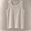 تاپ کراپ کبریتی بافت‌دار بدون آستین یقه گرد معلق در پس‌زمینه مینیمال بتنی | Ribbed sleeveless crop tank top with round neck floating against a minimalist textured background