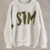 پلیور بافت تدی ضخیم با تایپوگرافی برجسته STM بر روی سینه در استودیوی مینیمال | Bouclé knit sweater with textured green STM front typography floating in minimal studio setting
