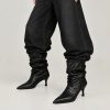 بوت چرم مشکی زنانه با طراحی افتاده (slouchy)، نوک تیز و پاشنه کوتاه مدل کیتن هندسی در پس‌زمینه سفید | Women’s black slouchy leather boots with pointed toe and geometric kitten heel on white background
